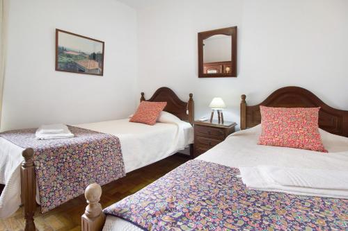 a bedroom with two beds and two mirrors at Casa do Adro do Soajo in Soajo