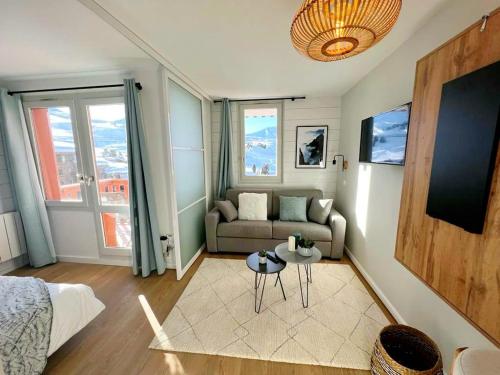 un salon avec un canapé et une table dans l'établissement L'Edelweiss, 2050m La Plagne, F2 Haut de gamme, à La Plagne Tarentaise