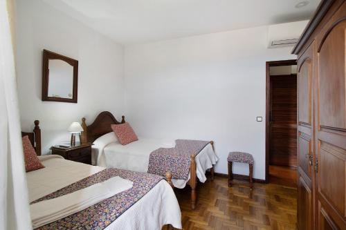 a hotel room with two beds and a mirror at Casa do Adro do Soajo in Soajo