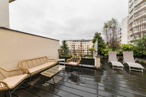 un ensemble de chaises et de tables sur un balcon dans l'établissement Duplex lumineux avec terrasse Courbevoie - 6P - FLAT-GUEST, à Courbevoie