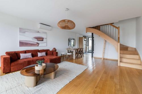 un salon avec un canapé rouge et une table dans l'établissement Duplex lumineux avec terrasse Courbevoie - 6P - FLAT-GUEST, à Courbevoie