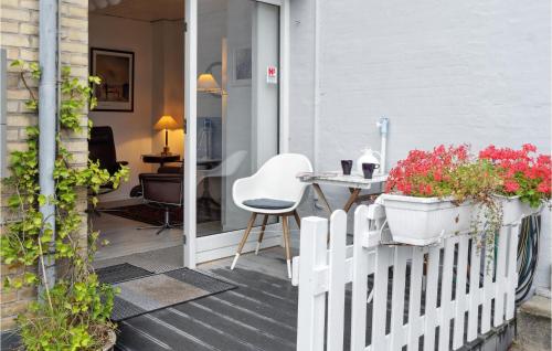 a porch with a white fence and a table and chairs at One-Bedroom Apartment In Stege in Stege