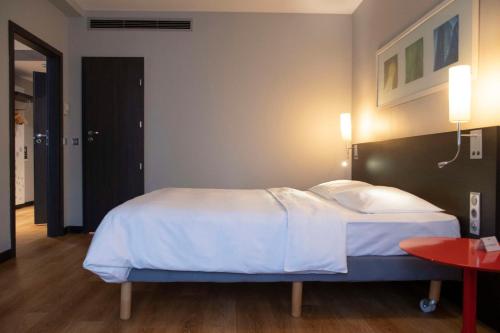 a bedroom with a bed with white sheets and pillows at Park Inn by Radisson Hotel Astana in Astana
