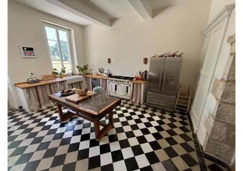 une cuisine avec une table et un réfrigérateur dans l'établissement Secluded manoir in SW France, à Lamontjoie
