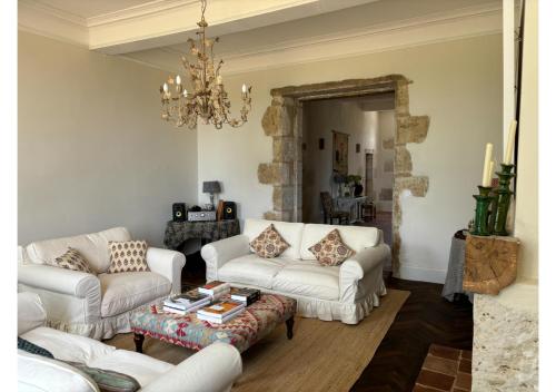 a living room with white couches and a chandelier at Secluded manoir in SW France in Lamontjoie