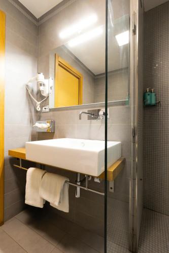 a bathroom with a white sink and a shower at Hotel Royal Caserta in Caserta