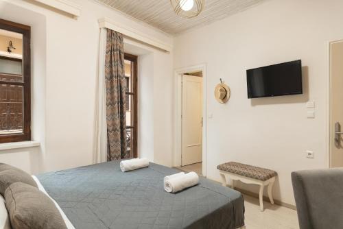 a bedroom with a bed and a tv on a wall at Elia Palazzo Hotel in Chania Town