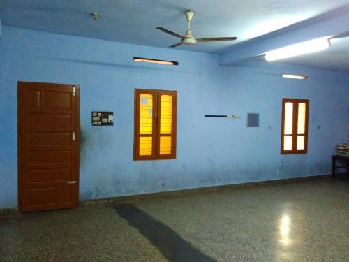 a room with three windows and a ceiling at Hotel Ganesh Lodge in Kanyakumari