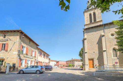 a car parked in front of a building with a tower at Le Munich - Les appartements de l'olivier in Loyettes