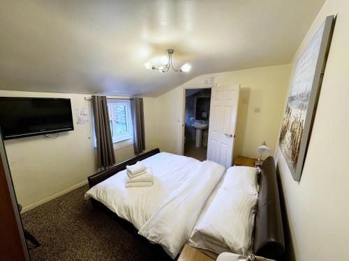 a bedroom with a bed with two pillows on it at The White Swan in Market Rasen