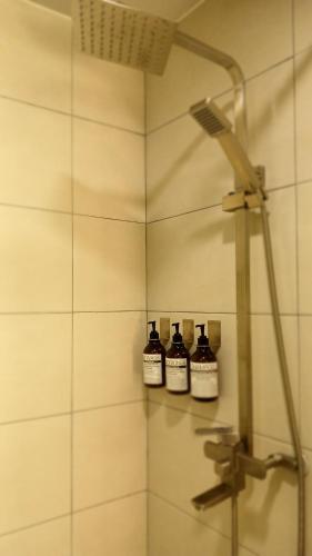 a bathroom with three bottles of alcohol in a shower at Stay here - entire house in Gongju
