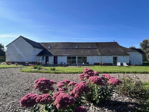 a house with pink flowers in front of it at LES INSOLITES DE SOPHIE in Boisgervilly