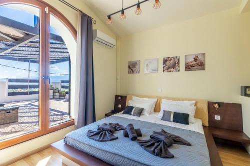 a bedroom with a bed and a large window at Thrapsano House with Private Pool for Families by Hospi Living in Heraklion