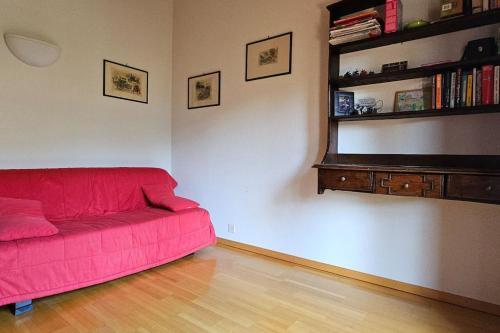 a red couch in a living room with a book shelf at Charming Chalet Downtown in Lens