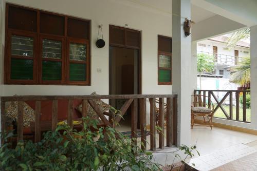 a porch of a house with a wooden railing at Cocolala Beach House in Nungwi