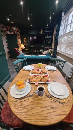 a wooden table with plates of food on it at Samuels' a duplex apartment by Spires Accommodation in Lichfield City Centre in Lichfield