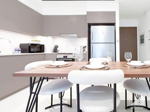 a kitchen with a wooden table and white chairs at Luxury & Elegance in Downtown Fountain Views in Dubai