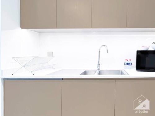 a white kitchen with a sink and a microwave at Luxury & Elegance in Downtown Fountain Views in Dubai
