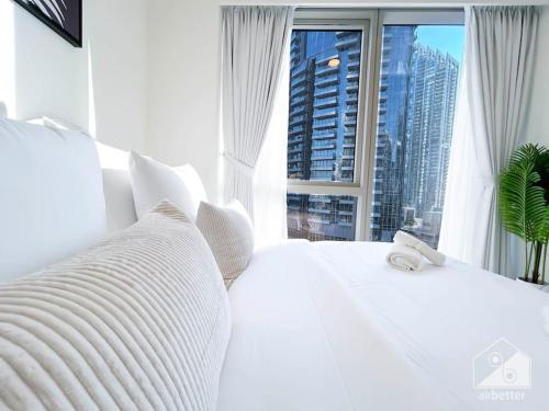 a bedroom with a white bed with a large window at Luxury & Elegance in Downtown Fountain Views in Dubai