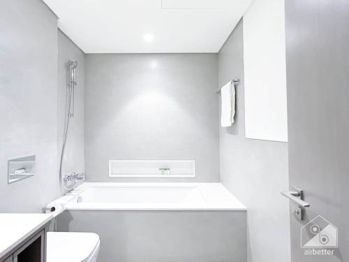 a white bathroom with a shower and a toilet at Luxury & Elegance in Downtown Fountain Views in Dubai