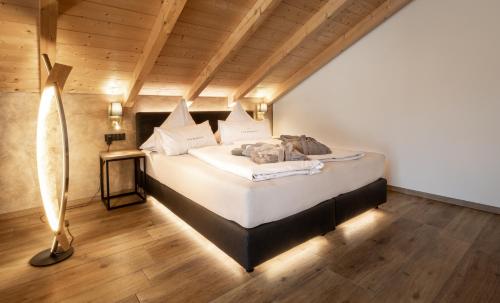 a bedroom with a bed in a room with wooden ceilings at FOR MOMENTS Apartments & Spa in Roßhaupten