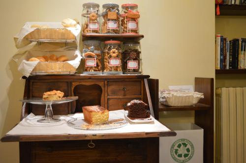 a table with cakes and jars of jam and desserts at Hotel Pallotta in Assisi
