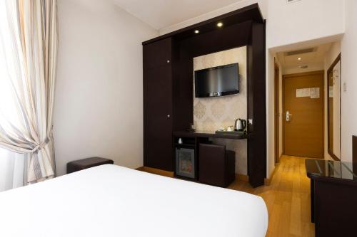 a hotel room with a bed and a tv at Hotel Royal Caserta in Caserta