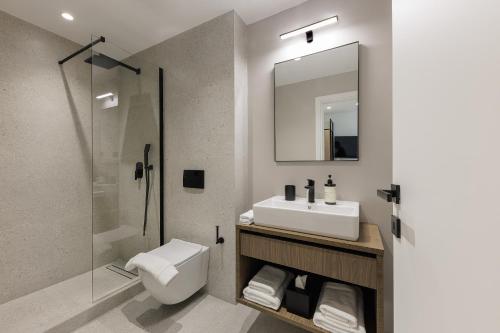 a bathroom with a sink and a toilet and a mirror at master Plaka in Athens