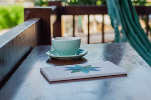 a coffee cup sitting on a table with a napkin at Villa Estrela Bungalow in Itacaré