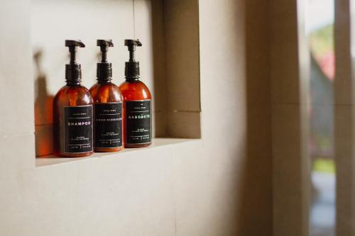 three bottles of alcohol sitting on a shelf at Villa Estrela Bungalow in Itacaré
