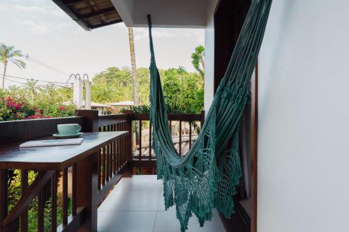 a hammock on the porch of a house at Villa Estrela Bungalow in Itacaré