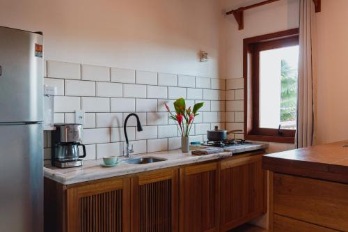 a kitchen with a sink and a window in it at Villa Estrela Bungalow in Itacaré