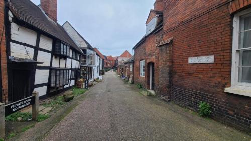 an empty street in an old town with brick buildings at Samuels' a duplex apartment by Spires Accommodation in Lichfield City Centre in Lichfield