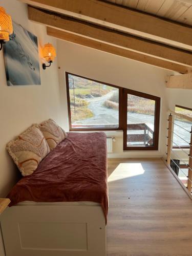a bedroom with a bed and a large window at Duplex 6 pers Tignes le lac in Tignes