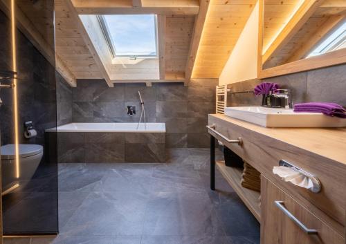 a bathroom with a sink and a bath tub at FOR MOMENTS Apartments & Spa in Roßhaupten