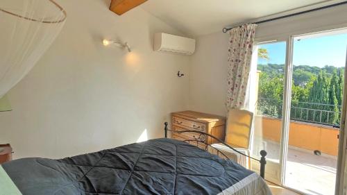 une chambre avec un lit et une fenêtre avec un balcon dans l'établissement Val Oréa 3, à Sainte-Maxime