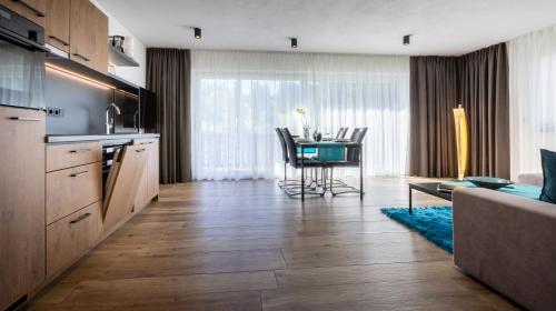 a kitchen with a table and a dining room at FOR MOMENTS Apartments & Spa in Roßhaupten