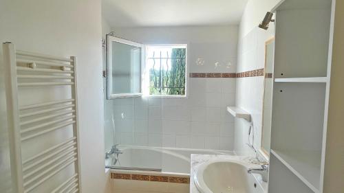 La salle de bains est pourvue d'un lavabo, d'une baignoire et d'une fenêtre. dans l'établissement Val Oréa 3, à Sainte-Maxime