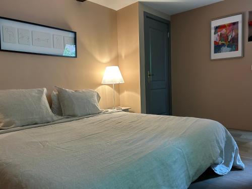a bedroom with a large white bed and a lamp at Cozy room just outside Utrecht Center, calm & green in Utrecht