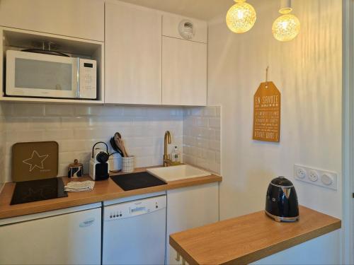 une cuisine avec un évier et un micro-ondes dans l'établissement Le Croix Du Sud - 2050m La Plagne F2 Vue montagne, à La Plagne Tarentaise