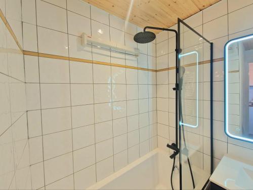 une salle de bain avec une douche avec pommeau de douche dans l'établissement Le Croix Du Sud - 2050m La Plagne F2 Vue montagne, à La Plagne Tarentaise