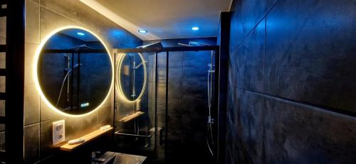La salle de bains est pourvue d'une douche et d'un miroir rond. dans l'établissement La Cabane - Plagne Village, F2 Ski aux pieds, à La Plagne Tarentaise