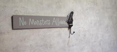 a sign that says no monsters alive on a wall at Top Point Chisinau Apartment in Chişinău