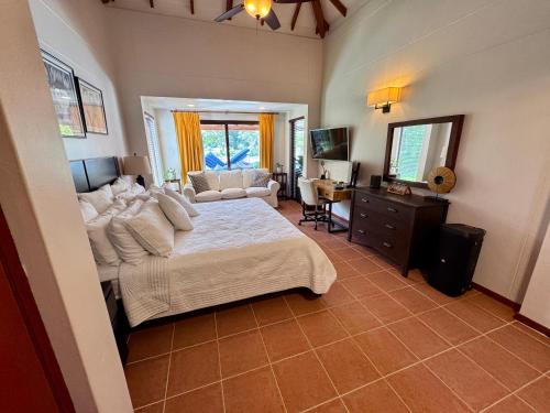 a bedroom with a large bed and a television at Villa Solara 6 - Luxury 6 Bedroom Villa with Pool, Golf & Lake View in Río Hato