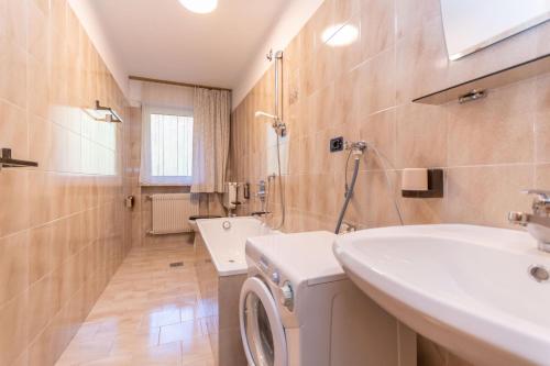 Un baño con lavadora y lavabo. en Appartamento Alessandra 106, en Vigo di Fassa
