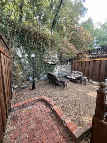 a backyard with a brick patio with a bench and a table at The Water Garden Suite in Eureka Springs