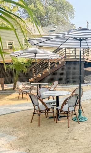 a group of tables and chairs with umbrellas at Swank Boutique Suites in Ashland