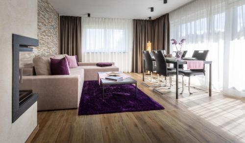 a living room with a couch and a table at FOR MOMENTS Apartments & Spa in Roßhaupten