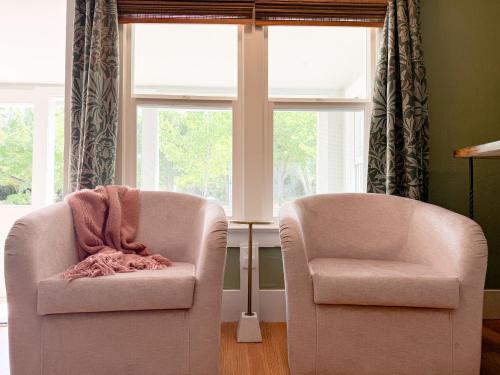 two chairs sitting in a room with a window at Swank Boutique Suites in Ashland