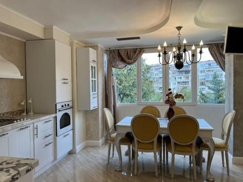 a kitchen with a table and chairs and a kitchen with a window at Ellie Soe Apartment Free parking 5 min to Metro in Sofia
